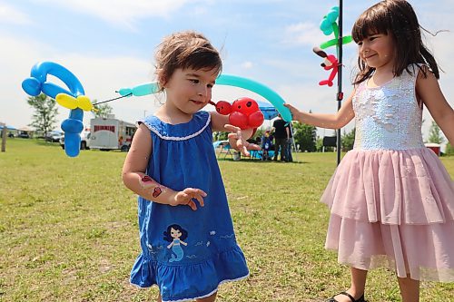 Jessica (l), 2, and Veronica, 4, Tegg play with a balloon butterfly and ladybug. Property restoration company Winmar hosted a fundraiser for the Samaritan House Food Bank on Saturday. (Photos by Geena Mortfield/The Brandon Sun)