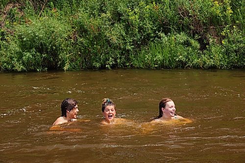 08072024
Siblings Cale Calcut, Leighton Calcut and Bailey Anderson swim together in the Little Saskatchewan River at the Daly - Whitehead Centennial Bridge on a hot Monday afternoon. 
(Tim Smith/The Brandon Sun)