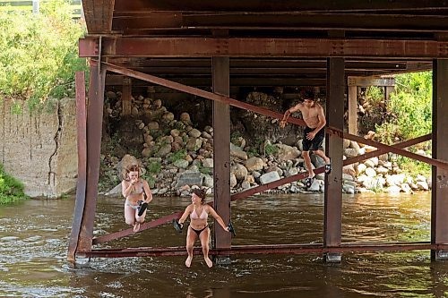 08072024
Siblings Bailey Anderson, Leighton Calcut and Cale Calcut leap from girders under the Daly - Whitehead Centennial Bridge into the Little Saskatchewan River while swimming on a hot Monday afternoon. 
(Tim Smith/The Brandon Sun)