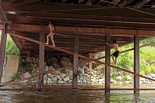 08072024
Siblings Leighton and Cale Calcut climb on girders under the Daly - Whitehead Centennial Bridge while swimming in the Little Saskatchewan River on a hot Monday afternoon. 
(Tim Smith/The Brandon Sun)