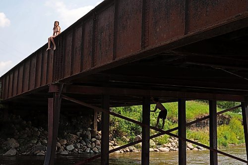 08072024
Siblings Leighton Calcut, Cale Calcut and Bailey Anderson climb on the Daly - Whitehead Centennial Bridge while swimming in the Little Saskatchewan River on a hot Monday afternoon. 
(Tim Smith/The Brandon Sun)