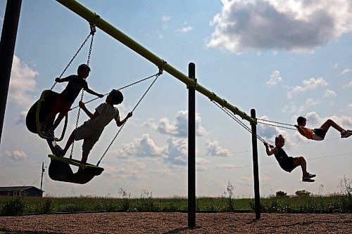 Kids play on a set of swings at Sioux Valley Dakota Nation on a hot and cloudy Tuesday afternoon. (Tim Smith/The Brandon Sun)