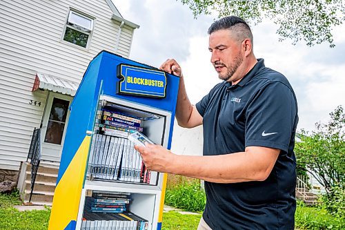 NIC ADAM / FREE PRESS
AJ Ongenae pictured alongside the Blockbuster themed little library on the front lawn of his Rossmere home.
240709 - Tuesday, July 09, 2024.

Reporter: Jura