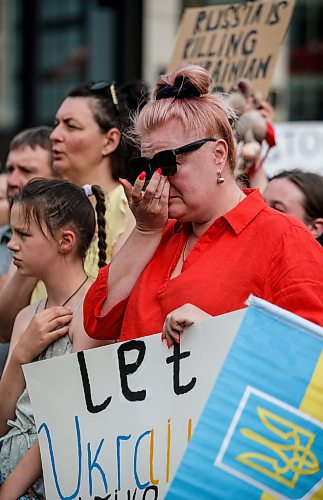 JOHN WOODS / FREE PRESS
A woman weeps as Ukraine supporters sing their anthem as they gather at the corner of portage and Notre Dame for a rally in Winnipeg Tuesday, July 9, 2024. 

Reporter: ?