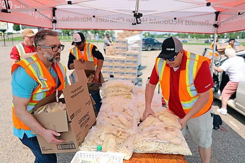 Volunteers from Heritage Co-op, McCain Foods and Ronald McDonald House Charities grab bags of frozen fries and hashbrowns to hand out in exchange for donations at the annual Free Fry Day fundraiser at the Keystone Centre on Wednesday. (Colin Slark/The Brandon Sun)