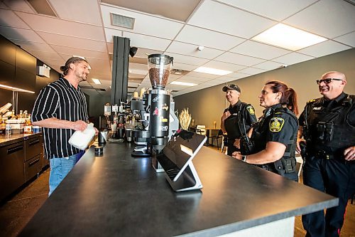 MIKAELA MACKENZIE / FREE PRESS

Sho coffee &amp; bar owner Heyhorii Alieksanov chats with foot patrol officers John Middleton (left), Vivian Smith, and Todd Martens (who are part of the Violent Crime Retail Theft Initiative) walk through Old Market Square in the Exchange District on Wednesday, July 10, 2024. 

For Chris story.

