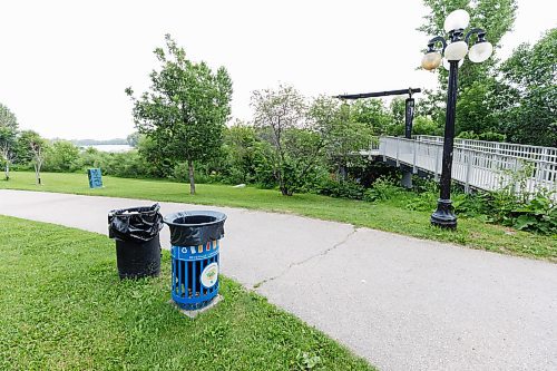 MIKE DEAL / FREE PRESS
Extra garbage bins line the sidewalk along Waterfront Drive where tents can be seen peeking through the underbrush along the Red River Wednesday.
240710 - Wednesday, July 10, 2024.