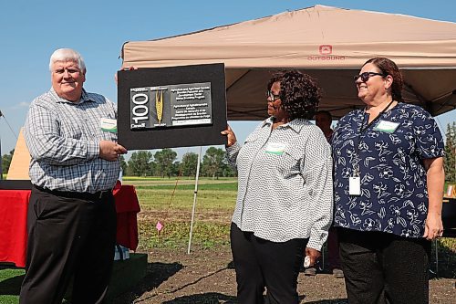 Federal officials Gilles Saindon, Felicitas Katepa-Mupondwa and Susan Bach unveil a 3D-printed plaque recognizing the centennial of the centre's barley breeding program on Thursday. (Tim Smith/The Brandon Sun)