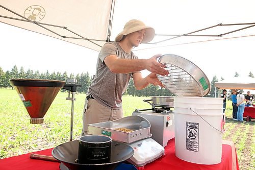 Summer Student Jack Claussen shows visitors how the assortment and sizing shaker works during the centennial celebration on Thursday. (Tim Smith/The Brandon Sun)