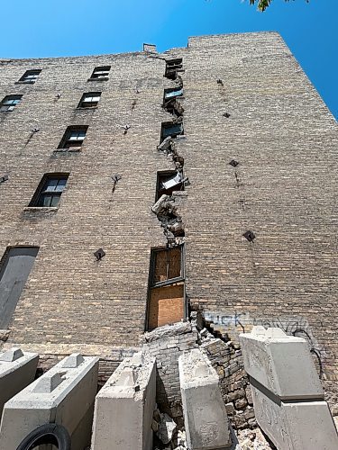 TYLER SEARLE / FREE PRESS

Residents living near 579 McDermot Ave. were forced to evacuate last week after the City of Winnipeg received an engineering assessment confirming the building was unsafe. Lanes and sidewalks around the property have been blocked with fencing. Large concrete blocks line the east exterior wall in an apparent effort to support the structure and prevent a collapse. 
July 11, 2024
