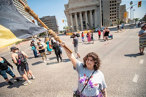 BROOK JONES / FREE PRESS
Winnipeg resident Jessica Courchene, who is from Sagkeeng First Nation, is pictured holding an American Indian Movement flag following a round dance at the intersection of Portage Avenue and Main Street in Winnipeg, Man., on the afternoon of Thursday, July 11, 2024. The round dance was organized following the announcement that a judge ruled serial killer Jeremy Anthony Michael Skibicki is criminally responsible for slaying four indigenous women in Winnipeg in early 2022.