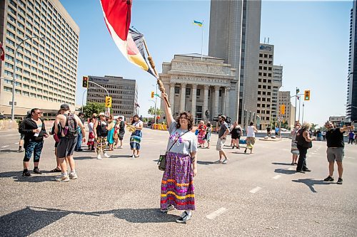 BROOK JONES / FREE PRESS
Winnipeg resident Jessica Courchene, who is from Sagkeeng First Nation, is pictured holding an American Indian Movement flag following a round dance at the intersection of Portage Avenue and Main Street in Winnipeg, Man., on the afternoon of Thursday, July 11, 2024. The round dance was organized following the announcement that a judge ruled serial killer Jeremy Anthony Michael Skibicki is criminally responsible for slaying four indigenous women in Winnipeg in early 2022.