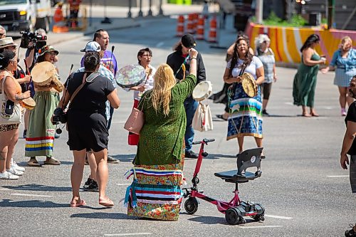 BROOK JONES / FREE PRESS
A woman raises her fist in the air during a round dance at the intersection of Portage Avenue and Main Street in Winnipeg, Man., on the afternoon of Thursday, July 11, 2024. The round dance was organized following the announcement that a judge ruled serial killer Jeremy Anthony Michael Skibicki is criminally responsible for slaying four indigenous women in Winnipeg in early 2022.