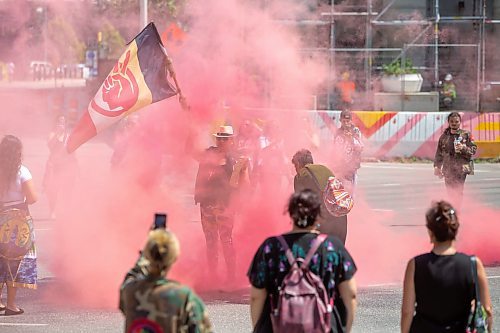 BROOK JONES / FREE PRESS
A woman holds an American Indian Movement flag and an aboriginal drum during a round dance at the intersection of Portage Avenue and Main Street in Winnipeg, Man., on the afternoon of Thursday, July 11, 2024. The round dance was organized following the announcement that a judge ruled serial killer Jeremy Anthony Michael Skibicki is criminally responsible for slaying four indigenous women in Winnipeg in early 2022.