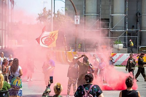 BROOK JONES / FREE PRESS
A woman holds an American Indian Movement flag during a round dance at the intersection of Portage Avenue and Main Street in Winnipeg, Man., on the afternoon of Thursday, July 11, 2024. The round dance was organized following the announcement that a judge ruled serial killer Jeremy Anthony Michael Skibicki is criminally responsible for slaying four indigenous women in Winnipeg in early 2022.