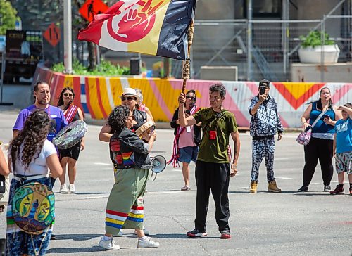 BROOK JONES / FREE PRESS
David Ferland, who is from Duck Bay, Man., holds an American Indian Movement flag during a round dance at the intersection of Portage Avenue and Main Street in Winnipeg, Man., on the afternoon of Thursday, July 11, 2024. The round dance was organized following the announcement that a judge ruled serial killer Jeremy Anthony Michael Skibicki is criminally responsible for slaying four indigenous women in Winnipeg in early 2022.