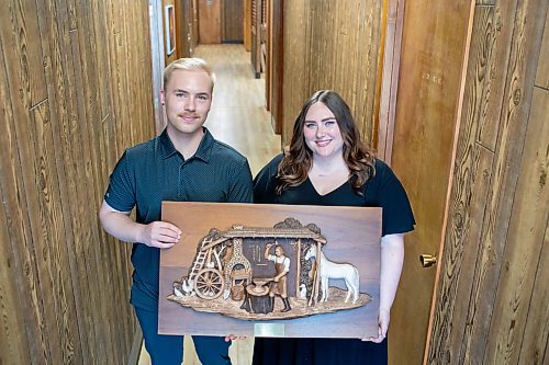 BROOK JONES / FREE PRESS
Dylan Bobrowski (left) and his sister Kayla hold the family emblem, which depicts a blacksmith hammering horse shoes, at Imperial Steel at 901 Century St., in Winnipeg, Man., Thursday, July 11, 2024. The brother-sister duo are junior executives and the fourth generation at Imperial Steel. The second floor offices are all original 1950s wood panelling.