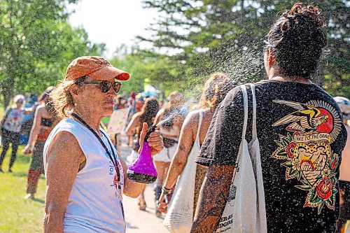 NIC ADAM / FREE PRESS
The 49th edition of the Winnipeg Folk Festival kicks off Thursday night with a music lineup that includes Lucinda Williams and Winnipeg&#x2019;s Roman Clarke.
Winnipeg Folk Fest Audience Services volunteer, Gayle Michalyshyn, cools attendees down with cold water as they enter the festival grounds.
240711 - Thursday, July 11, 2024.

Reporter: Eva Wasney