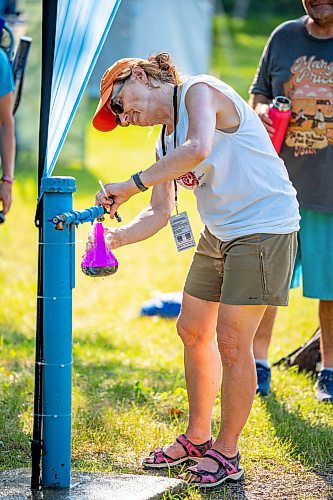 NIC ADAM / FREE PRESS
The 49th edition of the Winnipeg Folk Festival kicks off Thursday night with a music lineup that includes Lucinda Williams and Winnipeg&#x2019;s Roman Clarke.
Winnipeg Folk Fest Audience Services volunteer, Gayle Michalyshyn, cools attendees down with cold water as they enter the festival grounds.
240711 - Thursday, July 11, 2024.

Reporter: Eva Wasney