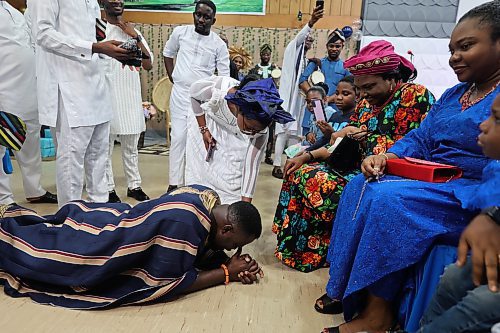 Peter Ariyo greets his wife's parents in accordance with traditions of southwest Nigeria while the parents pray for him during the couple's traditional wedding on Saturday. (Photos by Abiola Odutola/The Brandon Sun)