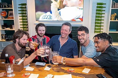 BROOK JONES / FREE PRESS
Joel Boulet (middle) and his sons Joe Boulet (left) and Sam Boulet (second from far left) and their friends Trevor Martin and Murad Okbamichael cheers their drinks while watching the Euro Cup final between England and Spain at the Elephant & Castle in Winnipeg, Man., Sunday, July 14, 2024.