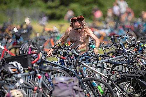 BROOK JONES / FREE PRESS
Folk Fest goer Alan Savage, 60, who is from Minneapolis, Minn., is pictured wearing bear ears while he locks up his Giant Bike as he arrives at the 49th Winnipeg Folk Festival at Birds Hill Provincial Park in Man., Sunday, July 14, 2024. Savage has been attending Folk Fest since 1994.