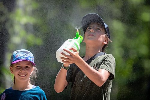 BROOK JONES / FREE PRESS
Folk Fest goer Calan Fontain, 13, (right) sprays mist in the air to keep himself and his sister Solia, 10, cool on a hot summer day as they attend the 49th Winnipeg Folk Festival with their parents at Birds Hill Provincial Park in Man., Sunday, July 14, 2024.