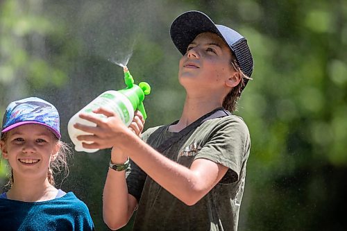 BROOK JONES / FREE PRESS
Folk Fest goer Calan Fontain, 13, (right) sprays mist in the air to keep himself and his sister Solia, 10, cool on a hot summer day as they attend the 49th Winnipeg Folk Festival with their parents at Birds Hill Provincial Park in Man., Sunday, July 14, 2024.