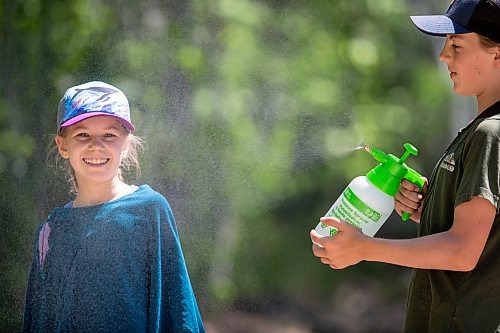 BROOK JONES / FREE PRESS
Folk Fest goer Calan Fontain, 13, (right) cools off his sister Solia, 10 on a hot summer day, by spraying mist in the air as they attend the 49th Winnipeg Folk Festival with their parents at Birds Hill Provincial Park in Man., Sunday, July 14, 2024.