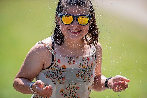 BROOK JONES / FREE PRESS
Folk Fest goer Tegan McCaul, 9, who is from Thunder Bay, Ont., keeps cool by taking advantage of the public shower at a cooling station at the 49th Winnipeg Folk Festival at Birds Hill Provincial Park in Man., Sunday, July 14, 2024. It was McCaul's third Folk Fest.