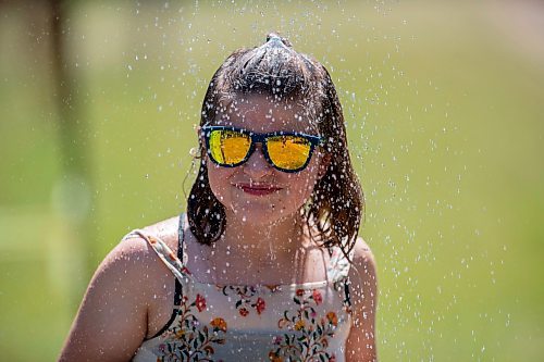 BROOK JONES / FREE PRESS
Folk Fest goer Tegan McCaul, 9, who is from Thunder Bay, Ont., keeps cool by taking advantage of the public shower at a cooling station at the 49th Winnipeg Folk Festival at Birds Hill Provincial Park in Man., Sunday, July 14, 2024. It was McCaul's third Folk Fest.