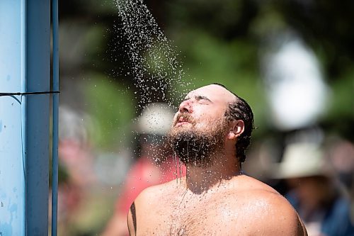 BROOK JONES / FREE PRESS
Folk Fest goer Carl Hiebert, 28, who is from Winnipeg, Man., keeps cool by taking advantage of the public shower at a cooling station at the 49th Winnipeg Folk Festival at Birds Hill Provincial Park in Man., Sunday, July 14, 2024. Hiebert has been attending Folk Fest since 2013.