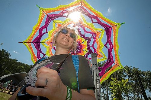 BROOK JONES / FREE PRESS
Folk Fest goer Liz Disenchanted, 30, who is from Winnipeg, Man., keeps cool on a hot summer day by using a giant sun umbrella as she attends the 49th Winnipeg Folk Festival at Birds Hill Provincial Park in Man., Sunday, July 14, 2024. Disenchanted has been attending Folk Fest since 2018.