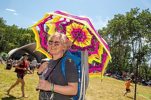 BROOK JONES / FREE PRESS
Folk Fest goer Liz Disenchanted, 30, who is from Winnipeg, Man., keeps cool on a hot summer day by using a giant sun umbrella as she attends the 49th Winnipeg Folk Festival at Birds Hill Provincial Park in Man., Sunday, July 14, 2024. Disenchanted has been attending Folk Fest since 2018.