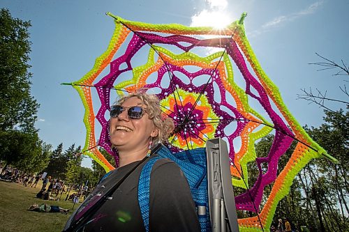 BROOK JONES / FREE PRESS
Folk Fest goer Liz Disenchanted, 30, who is from Winnipeg, Man., keeps cool on a hot summer day by using a giant sun umbrella as she attends the 49th Winnipeg Folk Festival at Birds Hill Provincial Park in Man., Sunday, July 14, 2024. Disenchanted has been attending Folk Fest since 2018.