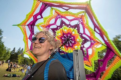 BROOK JONES / FREE PRESS
Folk Fest goer Liz Disenchanted, 30, who is from Winnipeg, Man., keeps cool on a hot summer day by using a giant sun umbrella as she attends the 49th Winnipeg Folk Festival at Birds Hill Provincial Park in Man., Sunday, July 14, 2024. Disenchanted has been attending Folk Fest since 2018.