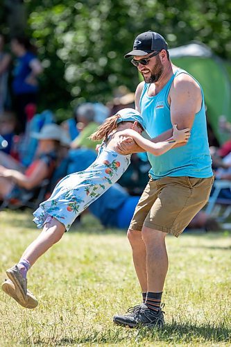 BROOK JONES / FREE PRESS
Folk Fest goer Nick Kolisnyk, 41, who is from Selkirk, Man., twirls his daughter Arianna, nine, as they listen to music by Inn Echo Tech Rider at the Snowberry Field stage at the 49th Winnipeg Folk Festival at Birds Hill Provincial Park in Man., Sunday, July 14, 2024.