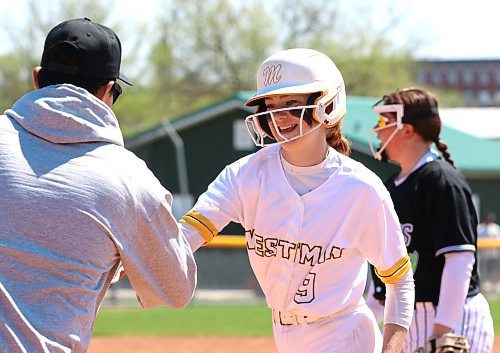 Charlie Shearer of the under-17 AAA Westman Magic smiles as she is congratulated for reaching base by first-base coach Logan Tanner earlier this season at Ashley Neufeld Softball Complex. The Magic organization has undergone a significant transformation in the last year as it moved from operating under the wing of Softball Brandon to becoming an independent entity. (Perry Bergson/The Brandon Sun)