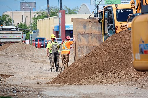 Construction crew members work to move a heavy piece of equipment on the southbound lanes of 18th Street near the Park Avenue intersection on Monday afternoon. (Matt Goerzen/The Brandon Sun)