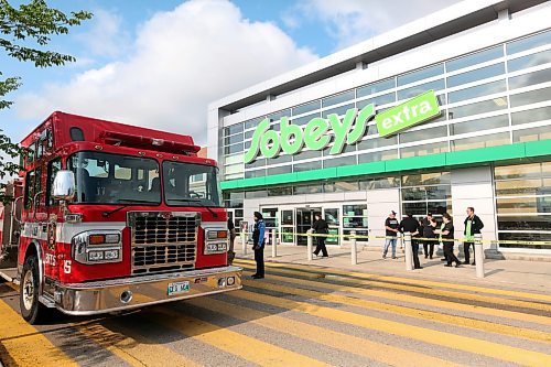 Sobeys Brandon South employees mingle outside behind warning tape while emergency crews are parked outside the east entrance at the Shoppers Mall on Monday morning after a compressor leak led to a refrigeration system failure at the grocery store. (Matt Goerzen/The Brandon Sun)