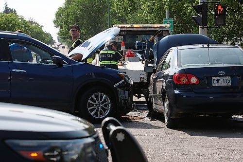 Full Tilt Towing operators work at the scene of a two-vehicle collision at the intersection of Victoria Ave. and 18th Str. by the traffic light on Monday afternoon. Photos: Abiola Odutola/The Brandon Sun