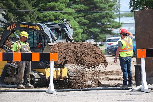 A compact track loader drops a bucket of sand in a hole during road construction on the southbound lanes of 18th Street on Monday afternoon. (Matt Goerzen/The Brandon Sun)