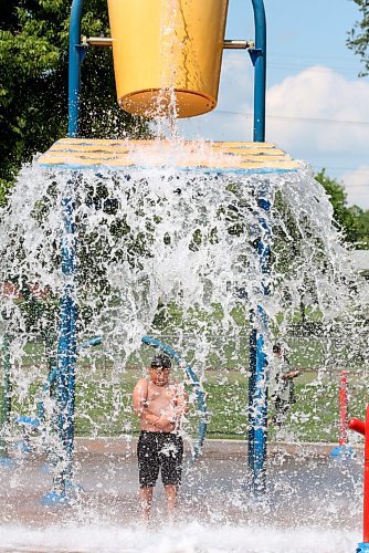 Nine-year-old Rayson from Regina gets doused with a huge bucket of water at Brandon's Rideau Spray Park on a warm and sunny Monday afternoon. (Matt Goerzen/The Brandon Sun)