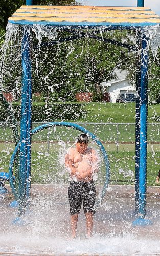 Nine-year-old Rayson from Regina gets drenched with water from a huge bucket at Brandon's Rideau Spray Park on a warm and sunny Monday afternoon. (Matt Goerzen/The Brandon Sun)