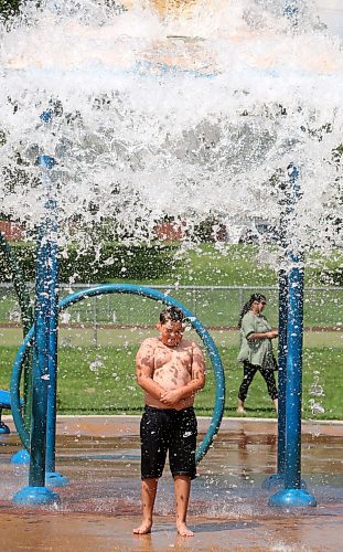 Nine-year-old Rayson from Regina is about to get drenched by the contents of a huge bucket of water at Brandon's Rideau Spray Park on a warm and sunny Monday afternoon. (Matt Goerzen/The Brandon Sun)