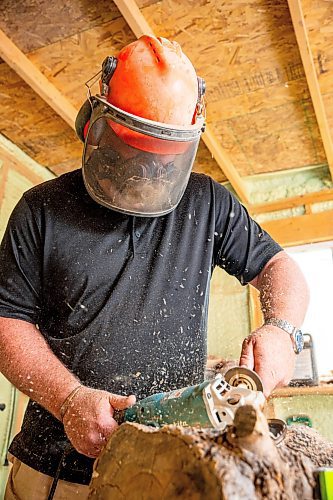 NIC ADAM / FREE PRESS
Sean Philips, 52, makes one-of-a-kind woodwork sculptures and pieces in the garage of his home from salvaged wood sourced here in MB.
Sean Philips cares a section of log into a bowl in his garage studio on Monday afternoon.
240715 - Monday, July 15, 2024.

Reporter: