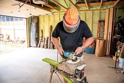 NIC ADAM / FREE PRESS
Sean Philips, 52, makes one-of-a-kind woodwork sculptures and pieces in the garage of his home from salvaged wood sourced here in MB.
Sean Philips cares a section of log into a bowl in his garage studio on Monday afternoon.
240715 - Monday, July 15, 2024.

Reporter: