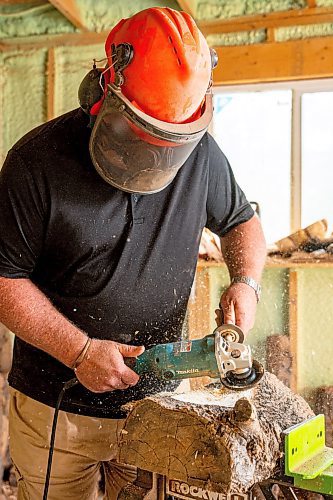 NIC ADAM / FREE PRESS
Sean Philips, 52, makes one-of-a-kind woodwork sculptures and pieces in the garage of his home from salvaged wood sourced here in MB.
Sean Philips cares a section of log into a bowl in his garage studio on Monday afternoon.
240715 - Monday, July 15, 2024.

Reporter: