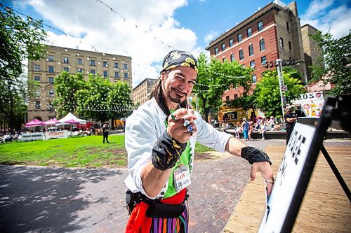 MIKAELA MACKENZIE / FREE PRESS

Captain Braggadocio, a.k.a. Tim Webster, changes the sandwich board at the Old Market Square outdoor stage as Fringe festival launches in Winnipeg on Wednesday, July 17, 2024.

