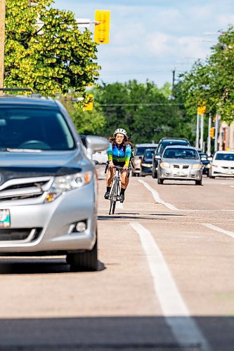 NIC ADAM / FREE PRESS
A cyclist rides past parked cars on St. Mary Ave., near Donald St., Wednesday.
240717 - Wednesday, July 17, 2024.

Reporter: Joyanne